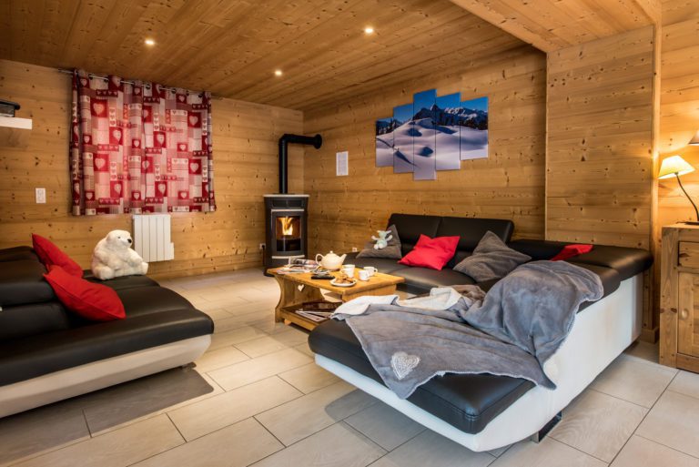 Lounge with sofas an logfire in chalet Snow Dream