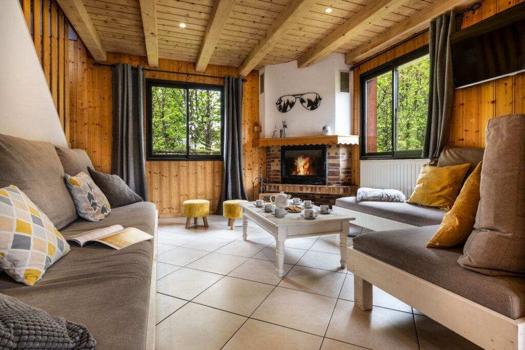 Lounge with fire place and sofas in chalet 3 Vallées located in le Bettaix - Chalets Lacuzon