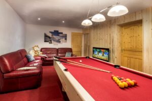 Game room with pool table, sofas and TV in chalet Snow Paradise