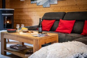 Cosy lounge with sofa and fireplace in chalet Snow Pearl located in le Bettaix - Chalets Lacuzon