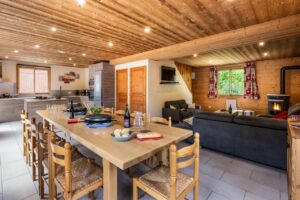 Living room with dining table and sofas in chalet Snow Pearl located in le Bettaix - Chalets Lacuzon