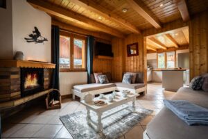 Cosy lounge with sofas , fire place and table in chalet Snow Paradise