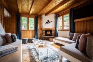 Cosy lounge with sofas and fire place in chalet Snow Paradise