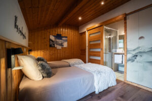 En suite bedroom with two beds in chalet Snow Paradise