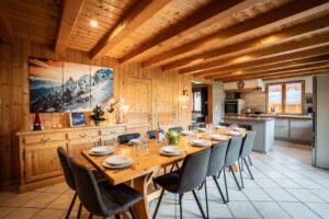 Open plan living space with large dining table and kitchen in chalet Snow Paradise