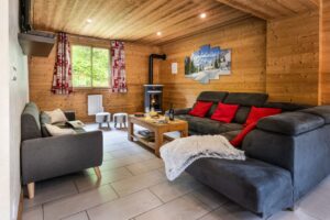 Lounge with sofas and fireplace in chalet Snow Mountain located in le Bettaix - Chalets Lacuzon