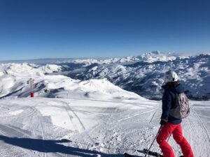 Les Menuires - skier admiring the view on the snowy mountains